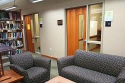 2 group study rooms with a table and couches outside of them